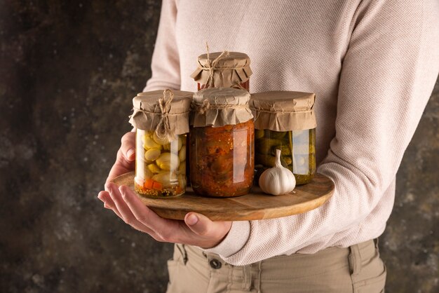 Close up hand holding board with jars