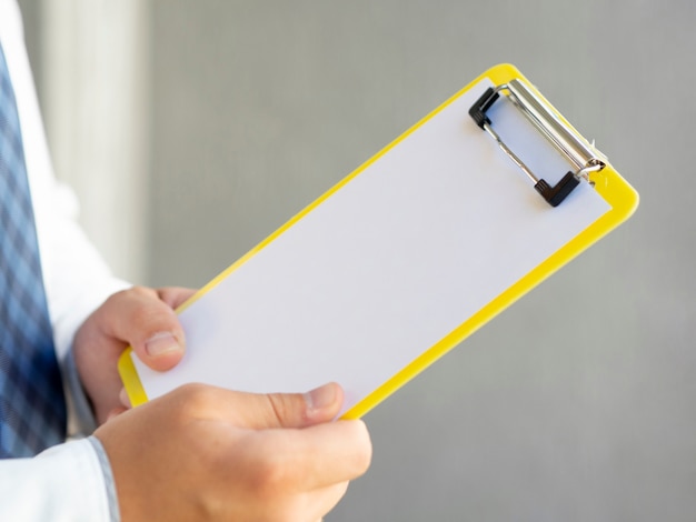 Free photo close-up hand holding a clipboard mock-up