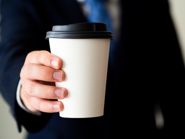 Free photo close-up hand holding coffee cup mock-up