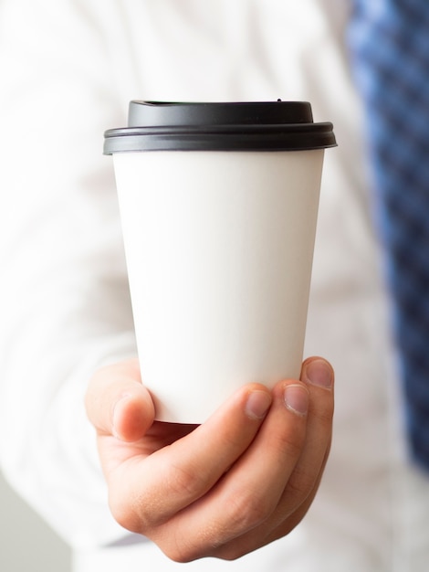 Free photo close-up hand holding coffee cup mock-up