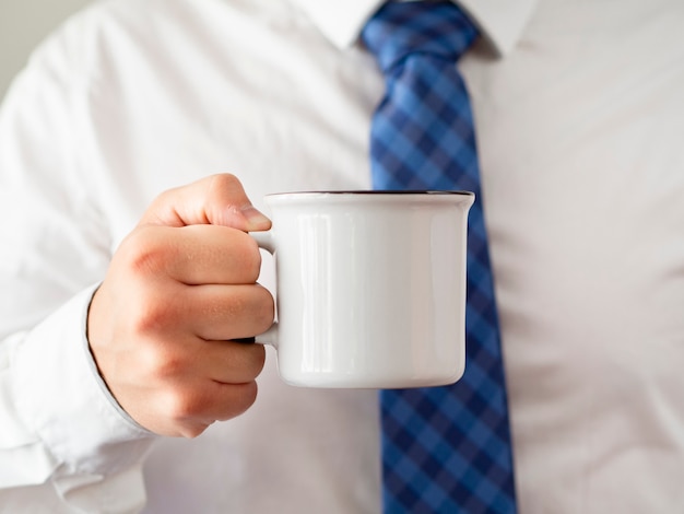 Free photo close-up hand holding coffee mug mock-up