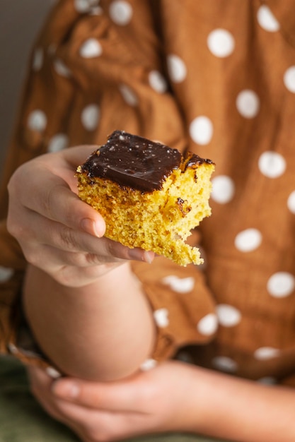 Free photo close-up hand holding delicious cake