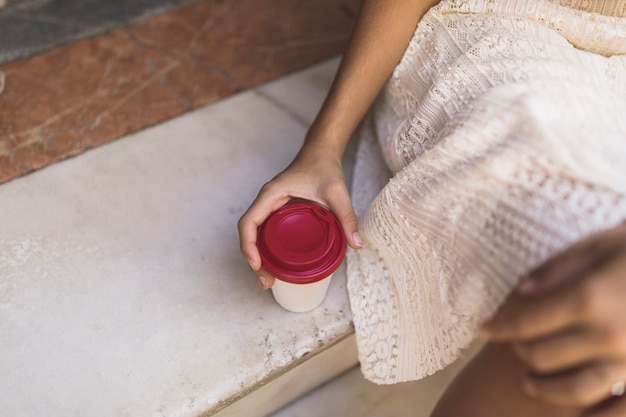 Close-up of hand holding disposable coffee cup