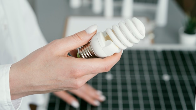 Close up hand holding eco lightbulb side view