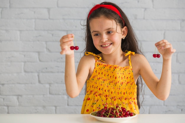 Close-up of hand holding fresh red cherries