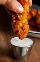 Free photo close up hand holding fried chicken