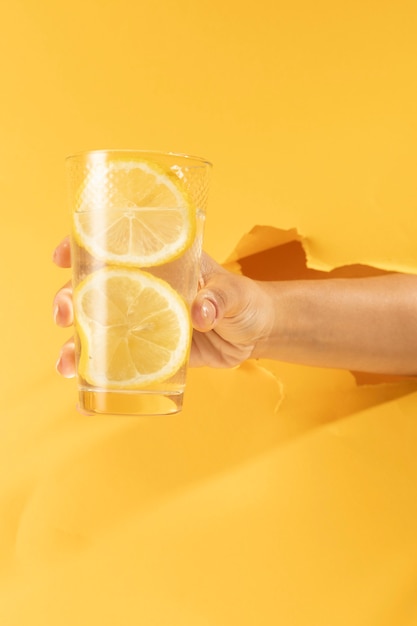 Close-up hand holding glass of lemonade