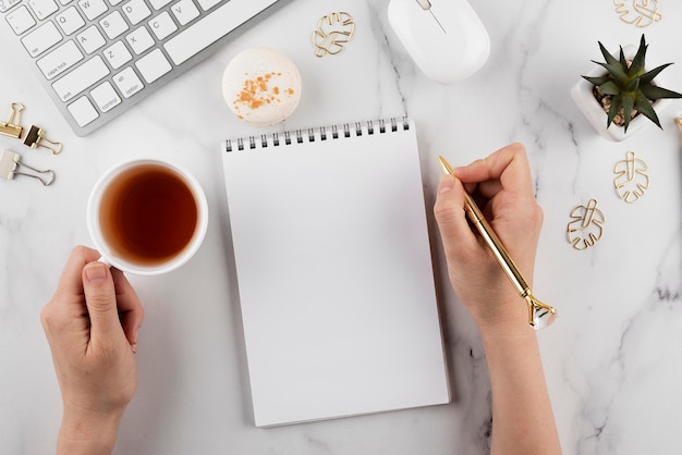 Close up hand holding golden pen and cup