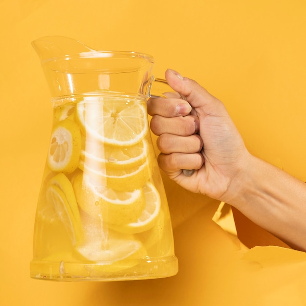 Close-up hand holding jar of lemonade