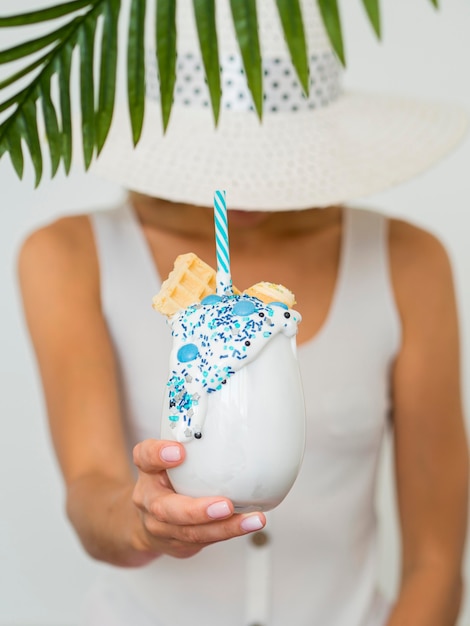 Close-up hand holding milkshake glass