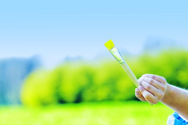 Close-up of hand holding a paintbrush