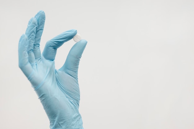 Close-up hand holding pill with copy space