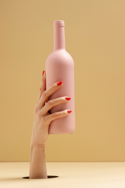 Free photo close up hand holding pink bottle