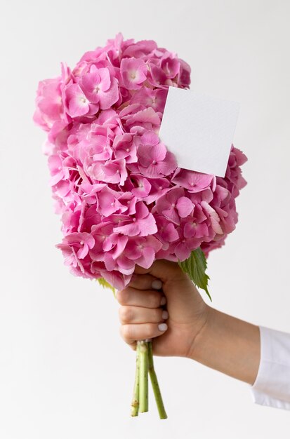 Close up hand holding pink hydrangea bouquet