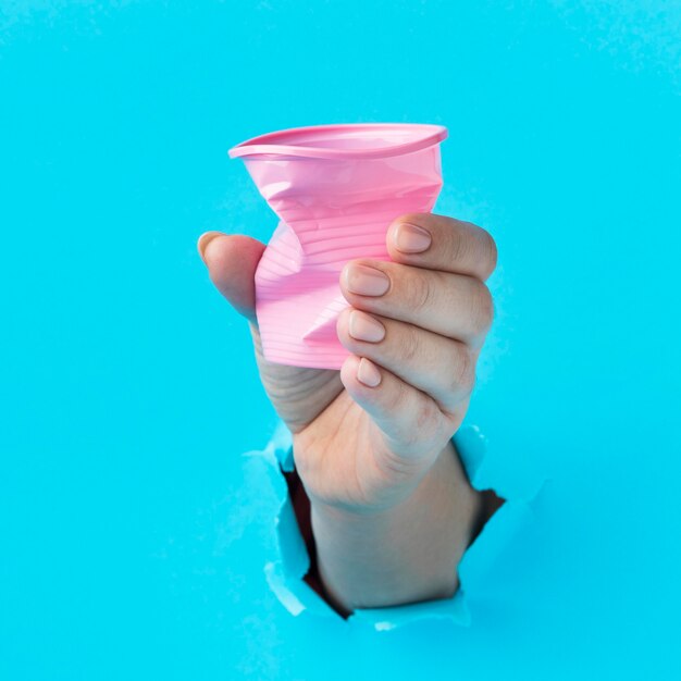 Close-up hand holding plastic cup