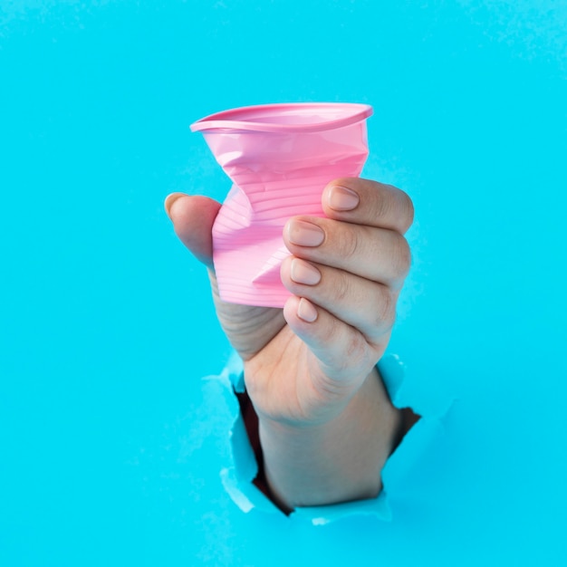 Close-up hand holding plastic cup