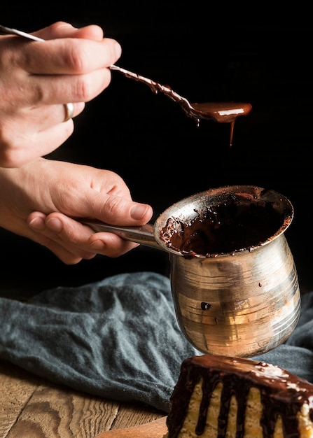 Free Photo close-up hand holding pot with hot chocolate and spoon