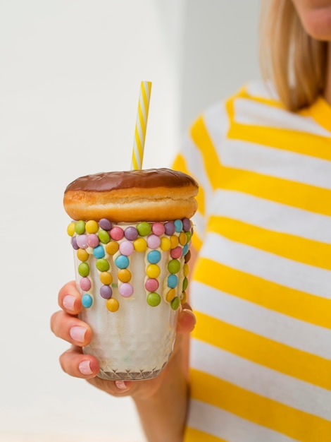 Close-up hand holding shake with doughnut