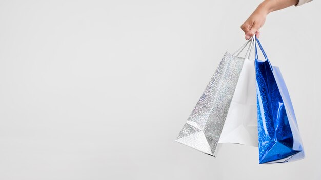 Close-up hand holding shopping bags with copy space