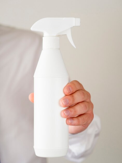 Close-up hand holding spray bottle mock-up