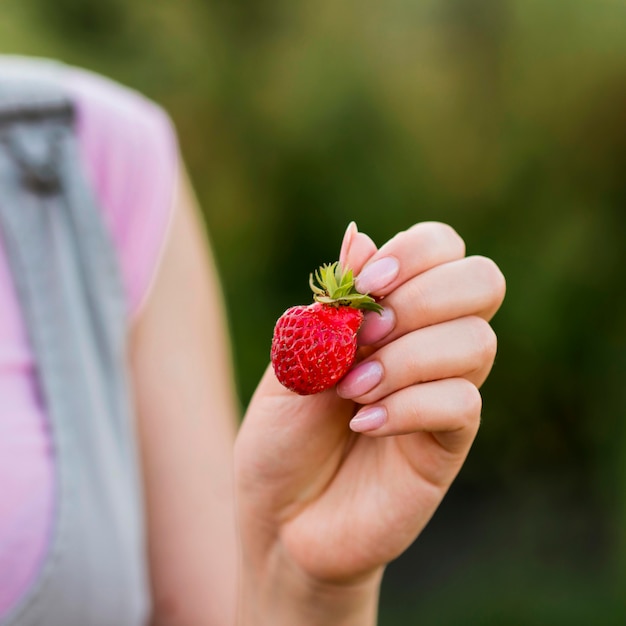 Close-up hand holding strawberry