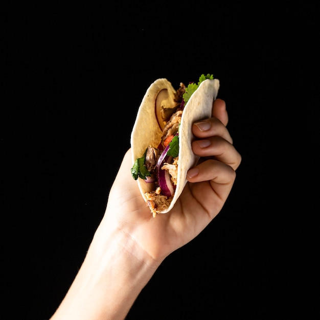 Free photo close-up hand holding taco with meat