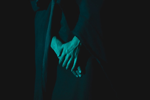 Close-up of hand holding together in the darkness