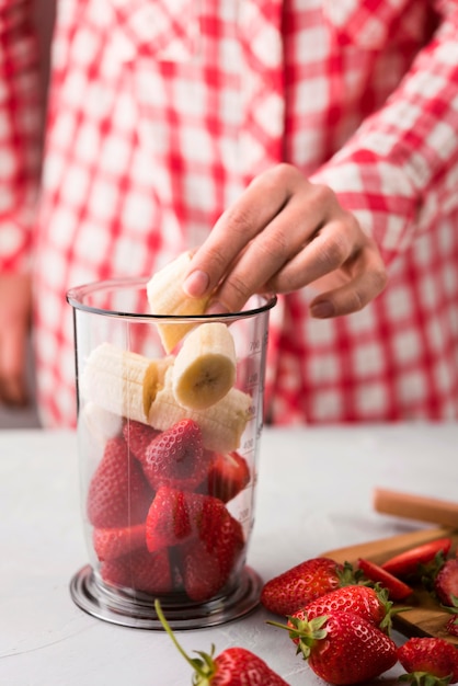 Close-up hand making smoothie