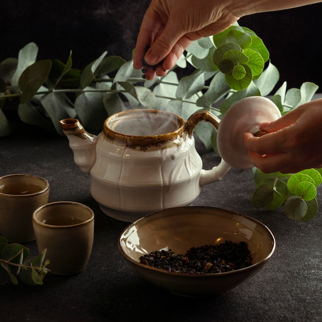 Free Photo close-up hand making tea in pot