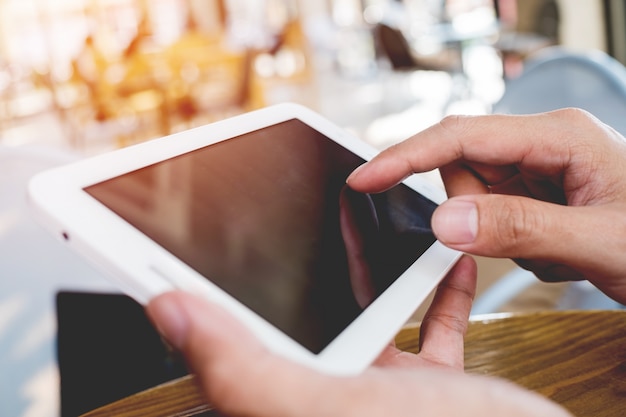 close up hand man using tablet at the coffee shop on table