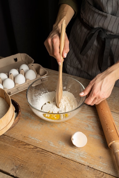 Close up hand mixing flour and egg