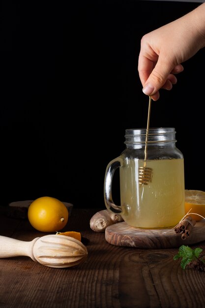 Close-up hand mixing jar filled with homemade lemonade