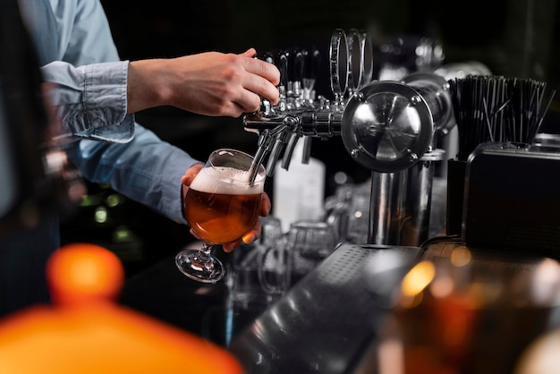 Free photo close-up hand pouring beer in glass