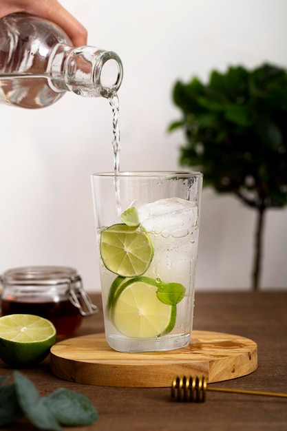 Close-up hand pouring drink in glass