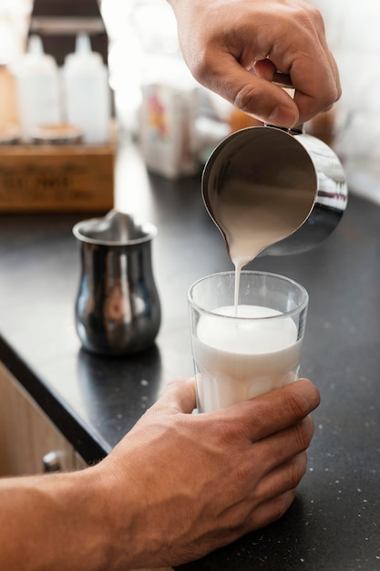 Free Photo close up hand pouring milk in glass