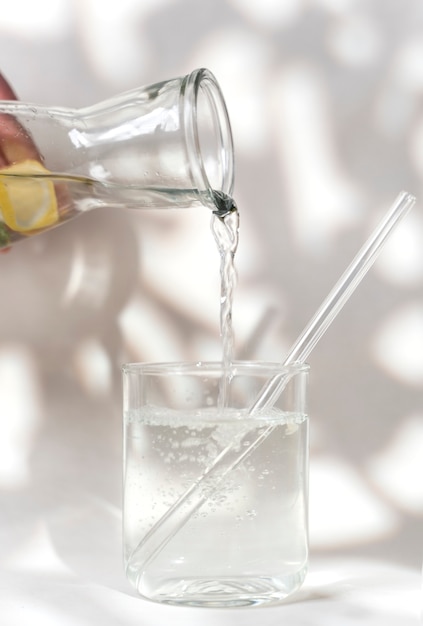 Close up hand pouring water in glass