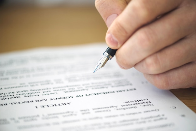 Close-up of hand signing contract