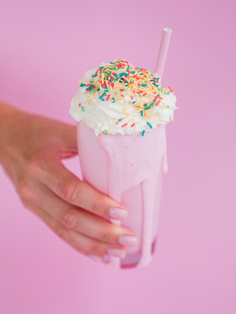 Free photo close-up hand tasty milkshake glass