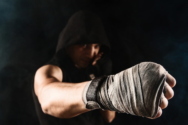 Free photo close-up hand with bandage of muscular man training kickboxing  on black