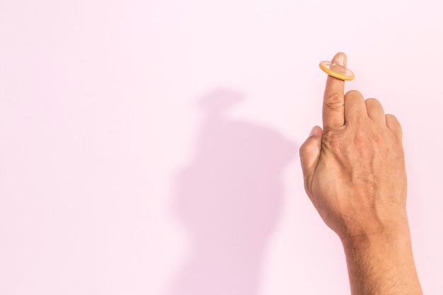 Free photo close-up hand with condom on the index finger