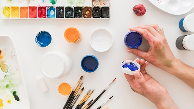 Close-up hand with paint containers