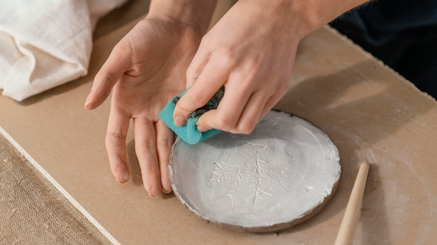 Free photo close-up hands cleaning plate