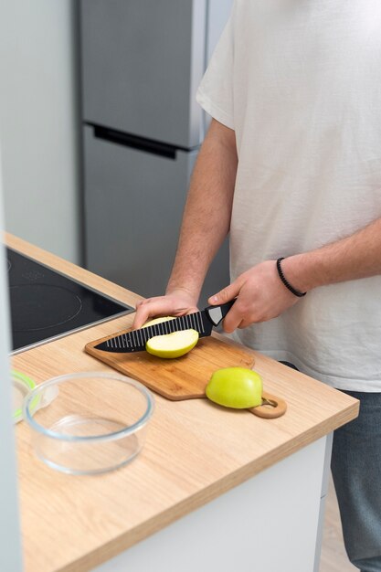 Close up hands cutting apple with knife