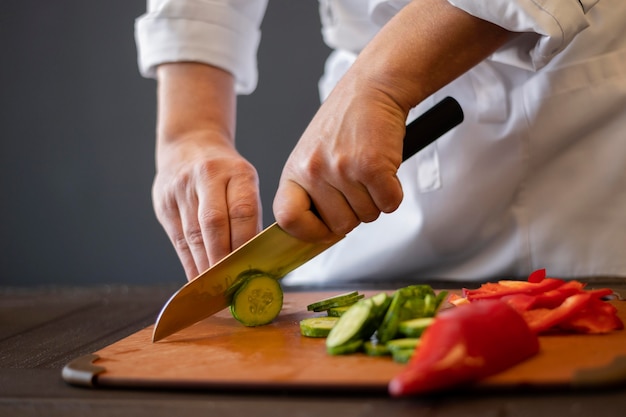 Close-up hands cutting cucumber