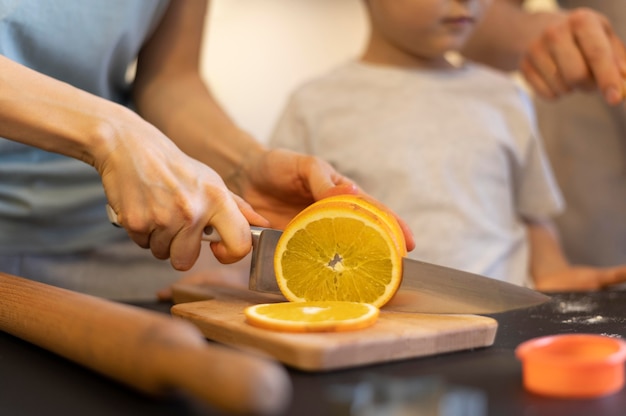 Close-up hands cutting orange