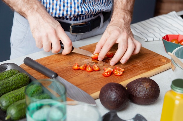 Close up hands cutting tomatoes