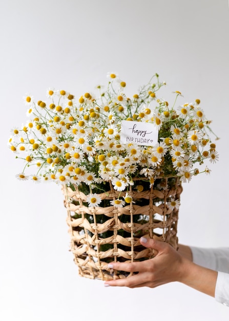 Free photo close up hands holding basket with flowers