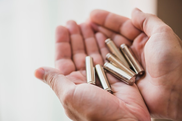 Close-up of hands holding battery cells