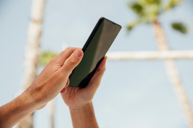 Free photo close-up hands holding black phone