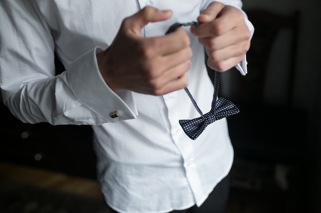 Free Photo close-up of hands holding a bow tie